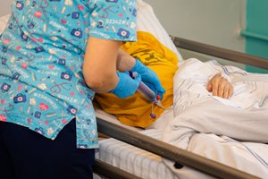 Pielęgniarka podająca lek pacjentowi.