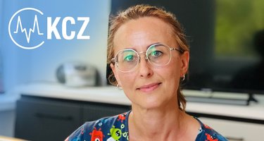 Kobieta w okularach, uśmiechająca się na tle biura.