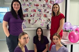 Grupa pracowników medycznych w kolorowych uniformach.