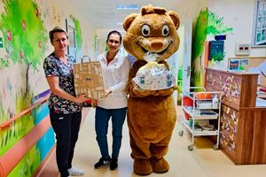 Dwie osoby z prezentami i maskotką lwa.
