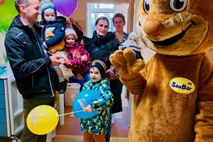 Rodzina świętująca z maskotką.