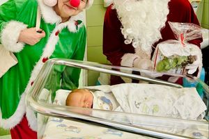 Święty Mikołaj z elfem przy noworodku.