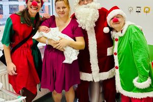 Święty Mikołaj z elfami i noworodkiem.