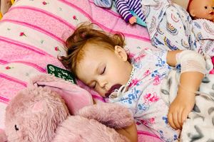 Śpiąca dziewczynka z pluszakiem.