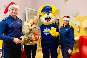 Policjanci z dziećmi i maskotką.