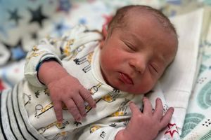 Noworodek śpiący w ubranku.