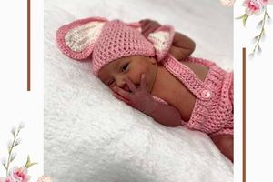 Noworodek w różowym ubranku.