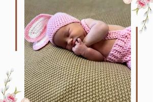 Noworodek w różowym ubranku.