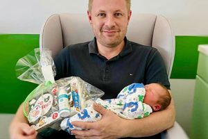 Nowo narodzone dziecko na rękach ojca.