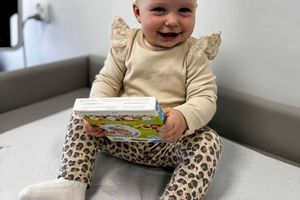 Uśmiechnięte dziecko trzymające książkę.