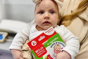 Małe dziecko trzymające książeczkę.