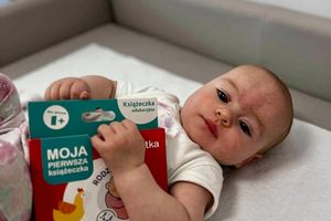 Bebek trzymający książeczkę.