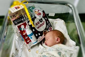 Noworodek w szpitalnym łóżeczku.