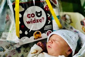 Noworodek śpiący obok zabawki.