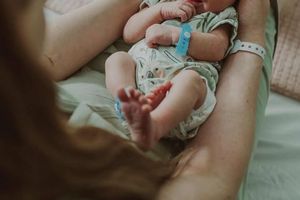 Noworodek w ramionach rodzica.