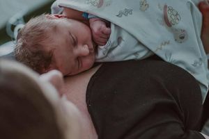 Noworodek leżący na klatce piersiowej.