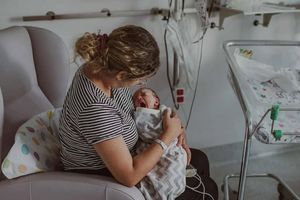 Mama trzymająca noworodka.