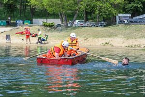 Ratownicy w łodzi ratują pływaka.