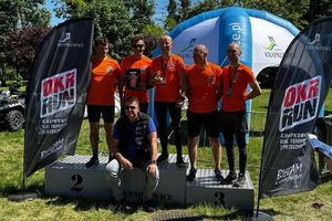 Zwycięzcy biegu w pomarańczowych koszulkach.