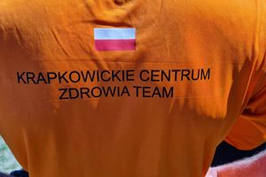 Pomarańczowa koszulka z napisem.