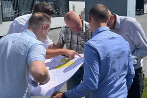 Grupa mężczyzn analizujących mapę.