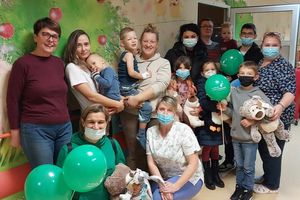 Grupa osób z dziećmi i balonami.