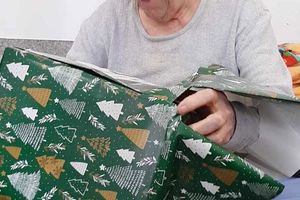 Osoba rozpakowująca prezent.