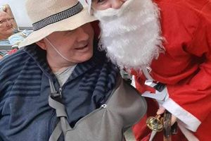 Osoba w kostiumie Mikołaja z uśmiechniętym mężczyzną.