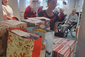 Mikołaj wręczający prezenty w placówce.