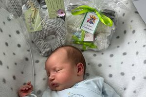 Noworodek śpiący w łóżeczku.