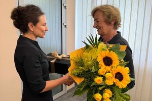 Kobieta wręczająca bukiet kwiatów.